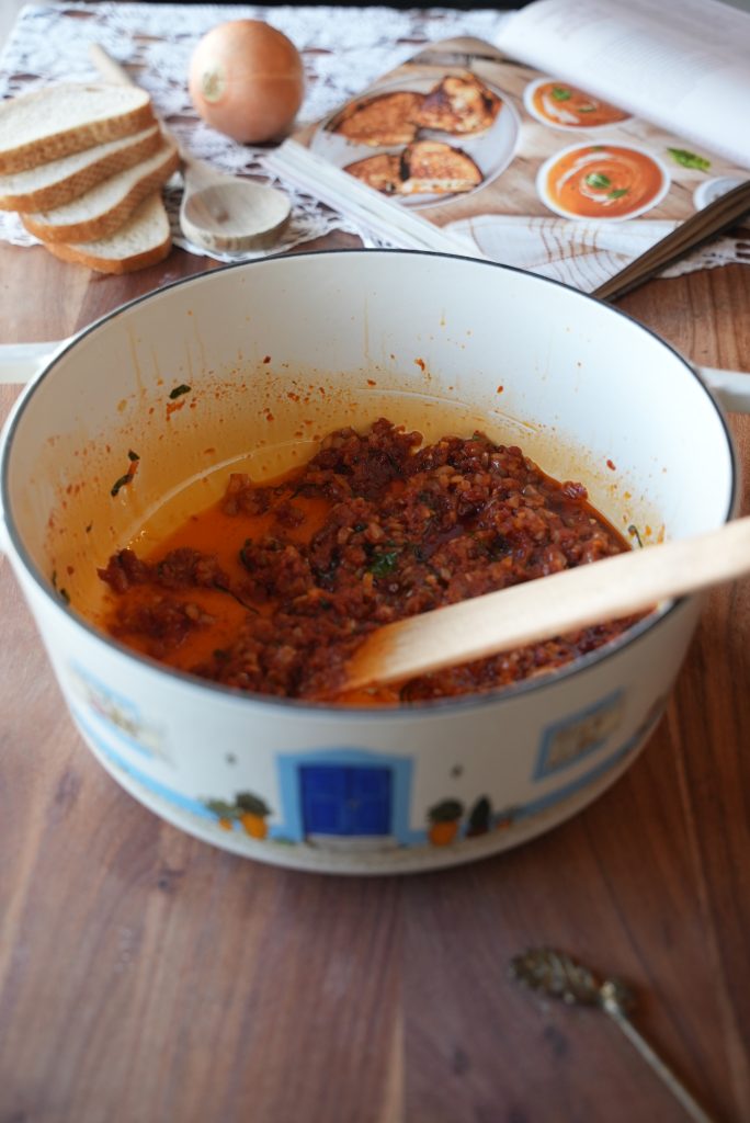 Cooking the tomato paste and basil in the pot