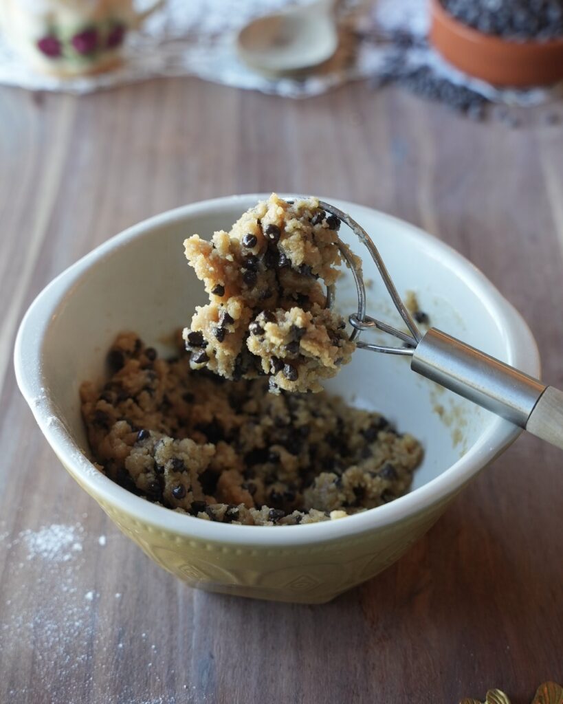 Salted brown butter edible cookie dough with mini chocolate chips in a mixing bowl with a whisk