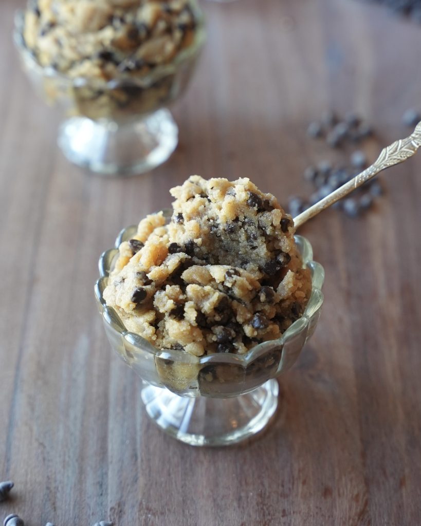Brown butter edible cookie dough served in a glass dessert cup with a gold spoon